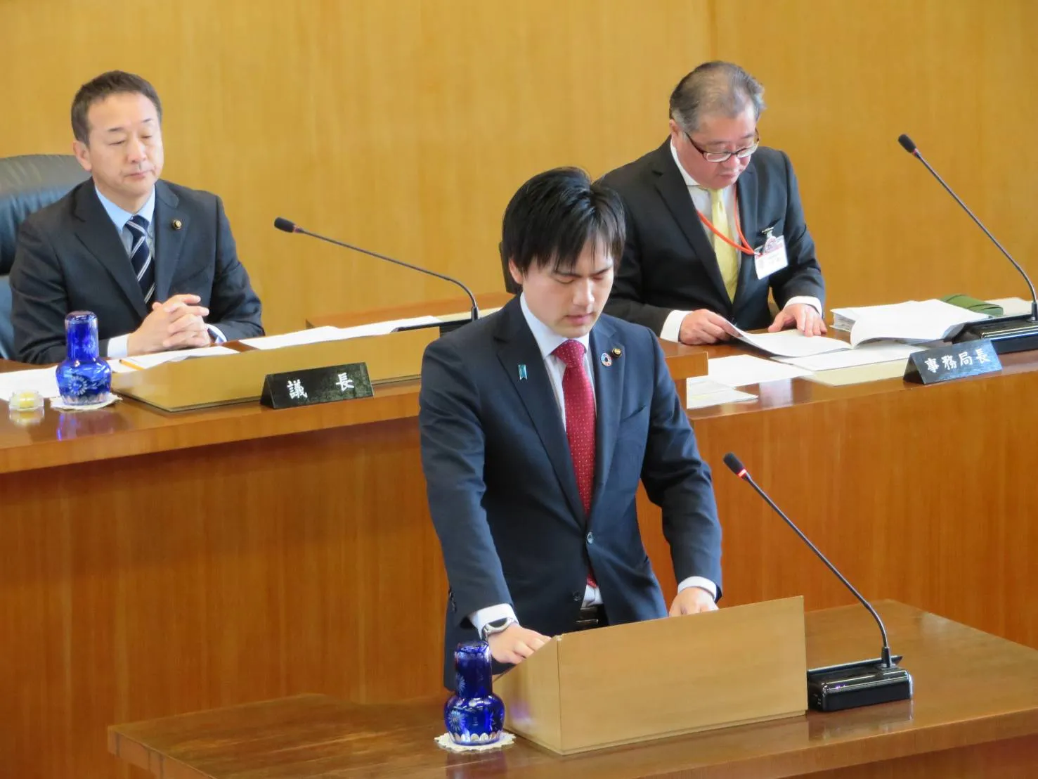 岸和田市議会の演壇で資料を見ながら質問する前田将臣